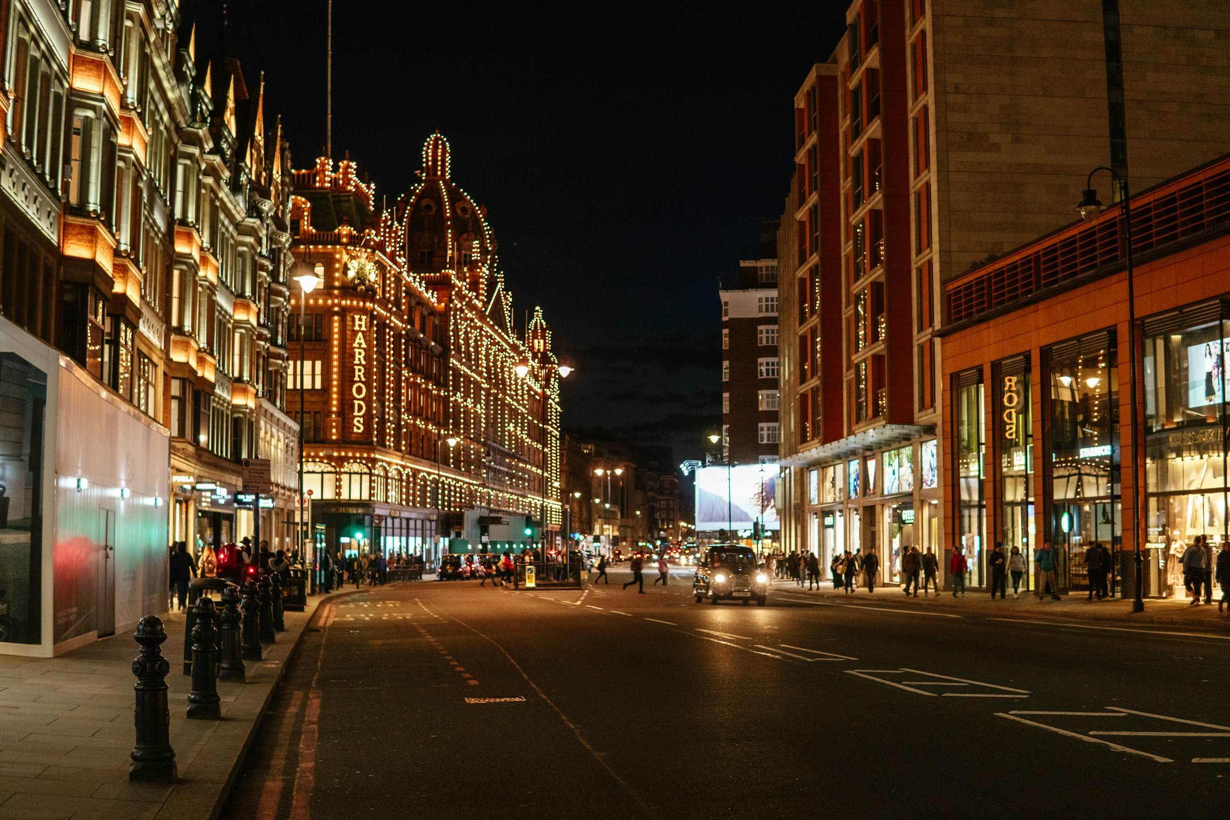 A city street at night, lit and under watch